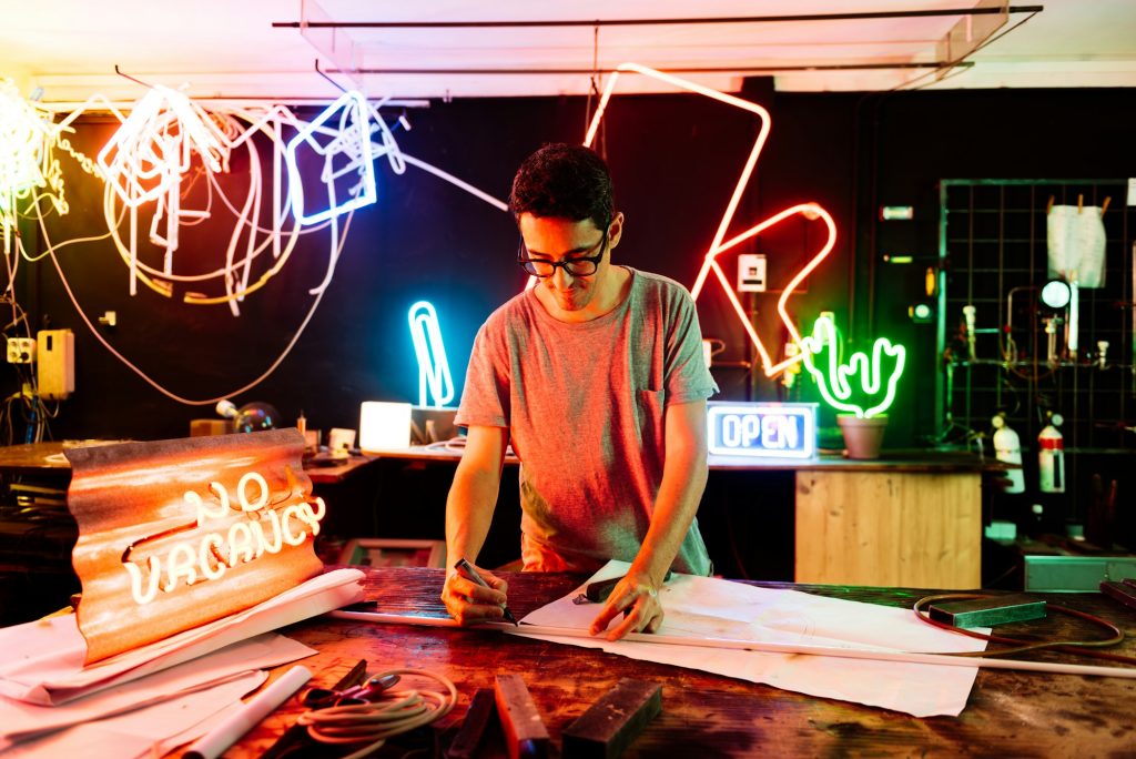Neon Sign Maker Working in a Vibrant Workshop