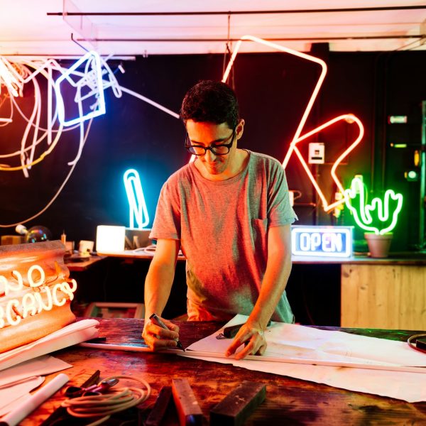Neon Sign Maker Working in a Vibrant Workshop